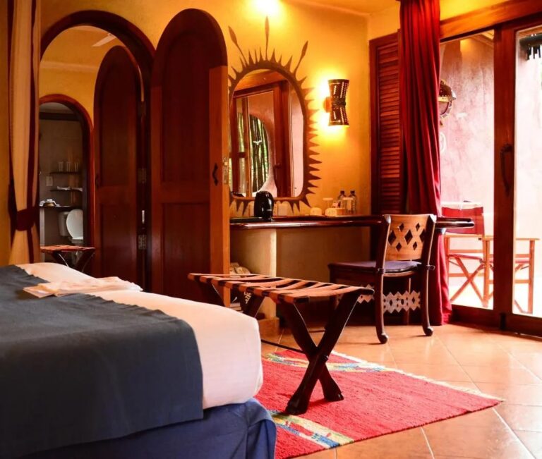 Ein Zimmer mit Rundbogentüren, einem Schreibtisch und einer offenen Glastür zur Terrasse