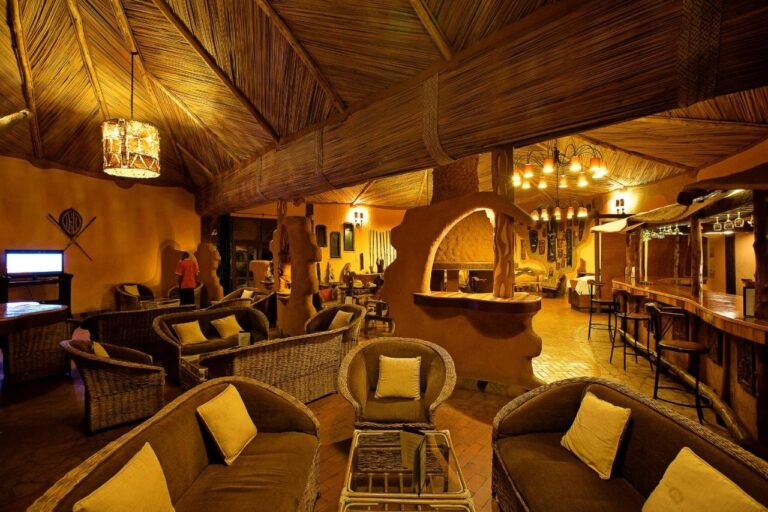 Die Lounge und die Bar, mit Rattansesseln mit gelben Kissen und Hockern an der Theke