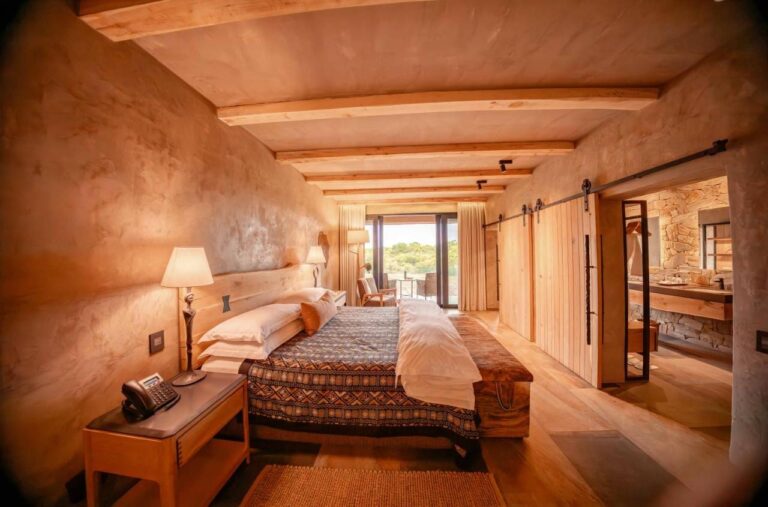 Eine Suite der Länge nach, vom Bett bis zur Terrasse, mit dem Bad hinter einer Schiebetür