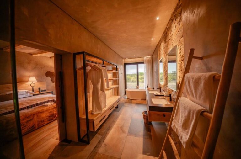 Der Durchgang zum Bad einer Suite, mit Kleiderschrank, Doppelwaschbecken und Badewanne