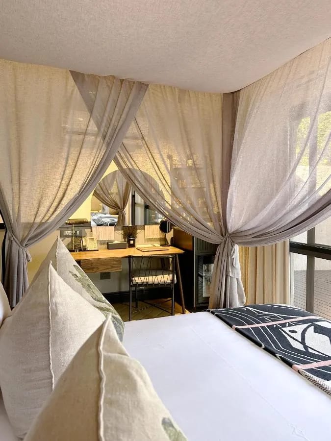 Die Schreibecke einer Suite, gesehen vom Bett mit Schleiervorhängen
