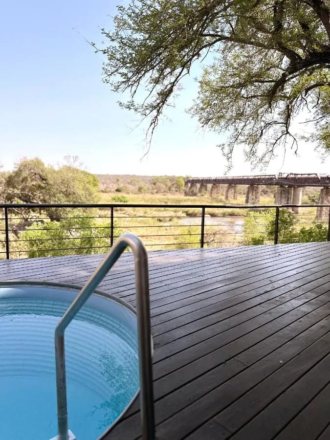 Der kleine Pool einer Suite mit Blick auf den Busch, in der Ferne die Brücke und der Zug