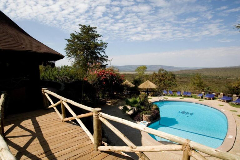 Der Pool der Mara Sopa Lodge von einer Holzterrasse aus, mit Blick auf Busch und Hügel