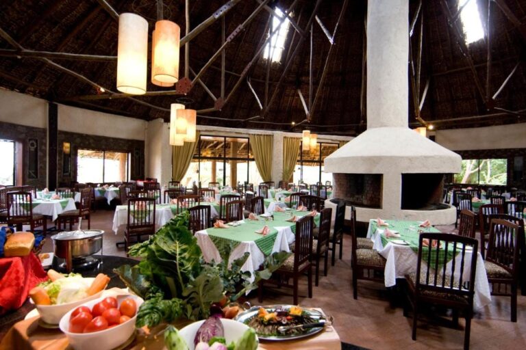 Das Restaurant mit grün gedeckten Tischen und einem Gemüsebuffet im Vordergrund
