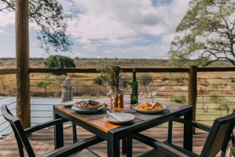 Ein Essen auf einem Tisch der Holzterrasse, mit Blick auf den Busch