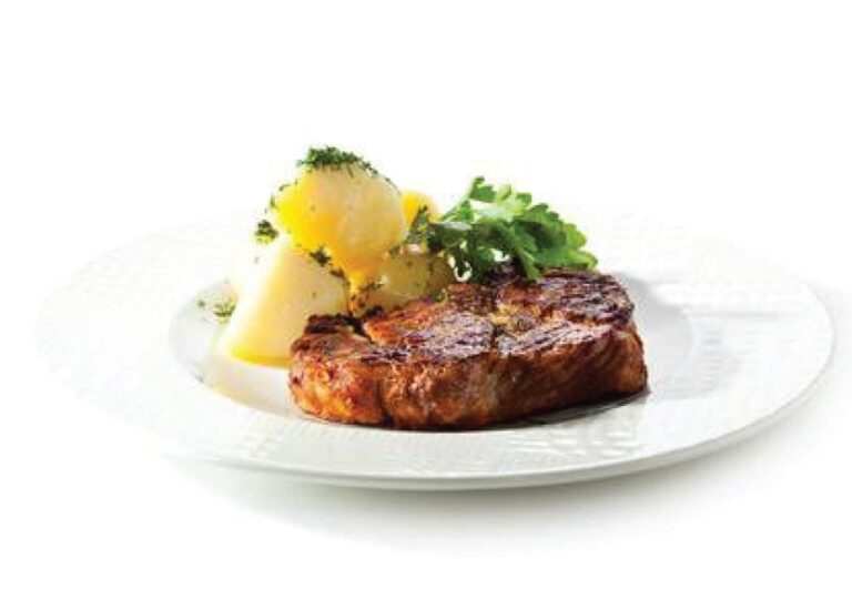 Ein Stück gegrilltes Fleisch mit Kartoffeln und Kräutern