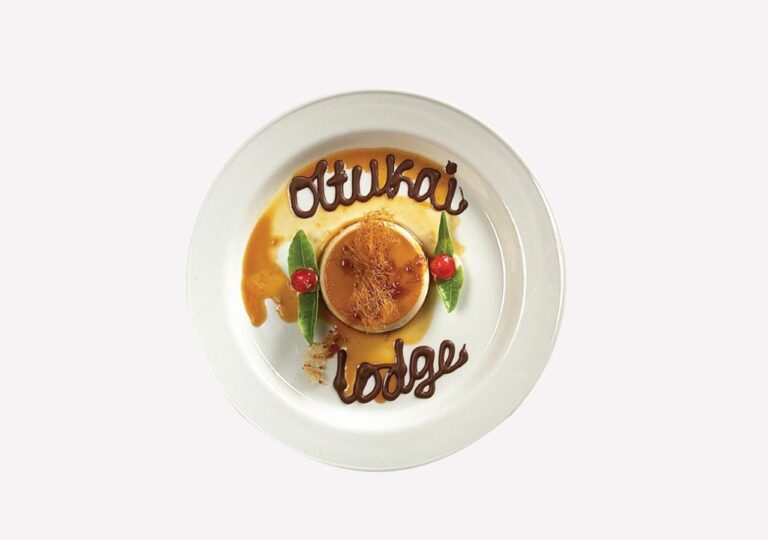 Ein Karamellpudding, auf dem Teller steht in Schokolade Ol Tukai Lodge geschrieben