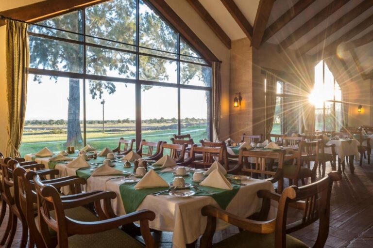 Das Restaurant des Sweetwaters Serena Camps mit gedeckten Tischen vor einer großen Fensterfront zur Ebene