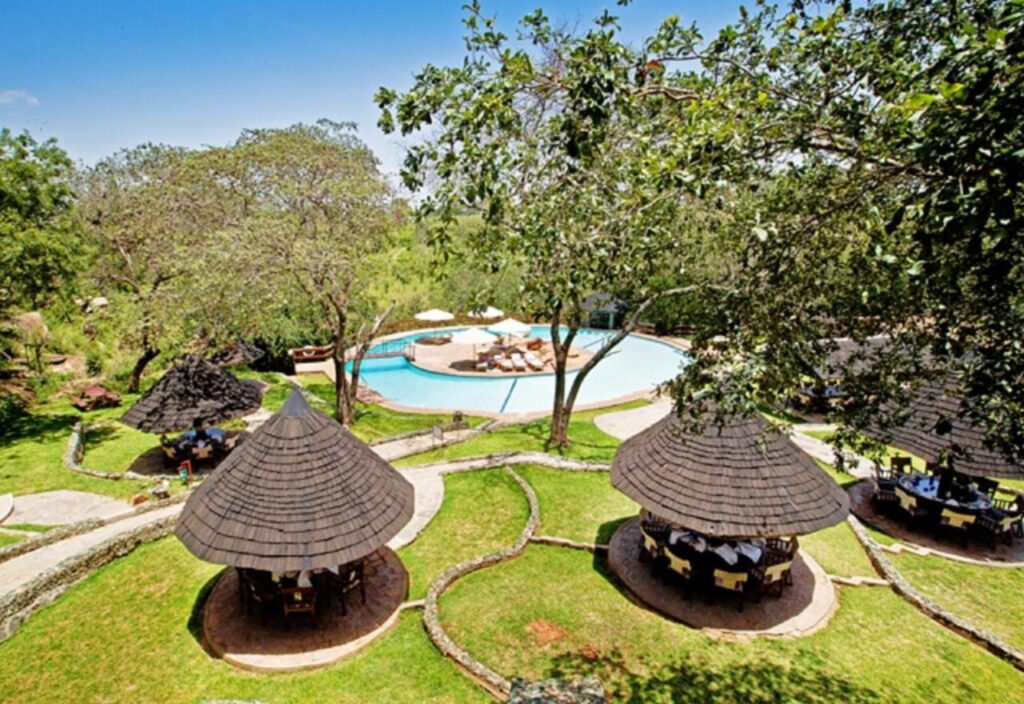 Der Pool der Tarangire Sopa Lodge und seine Strohschirme, mitten zwischen den Bäumen