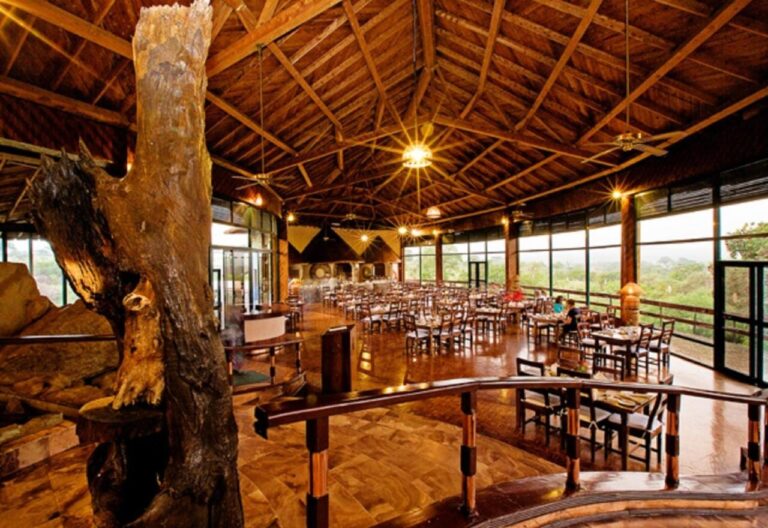 Das Restaurant der Lodge, seine Tische offen zum Busch und ein Baumstamm in der Mitte