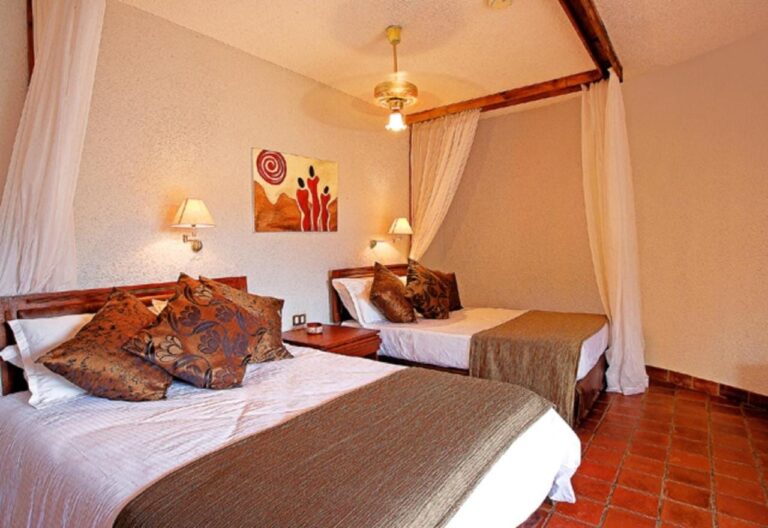 Ein Zimmer mit zwei Betten und Kissen mit afrikanischen Mustern